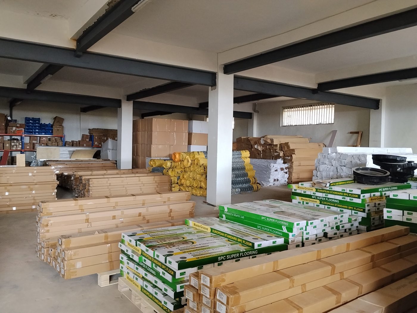 Tuala warehouse — SPC flooring stacked to the ceiling